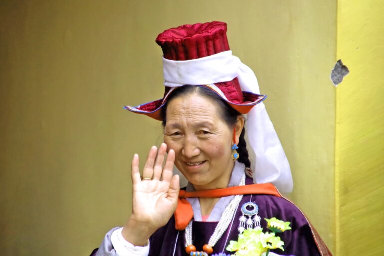 Woman in traditional attire waves hello