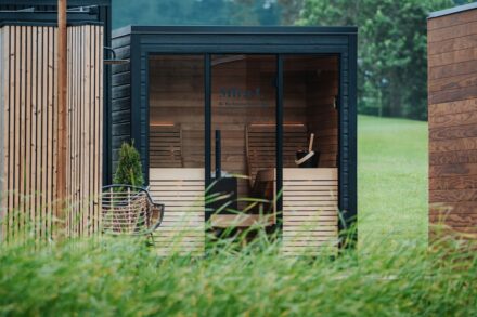 art therapy healing guide benefits modern Modern wooden sauna cabins in a grassy field.