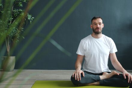 Chakra Healing Man meditating in lotus pose on yoga mat