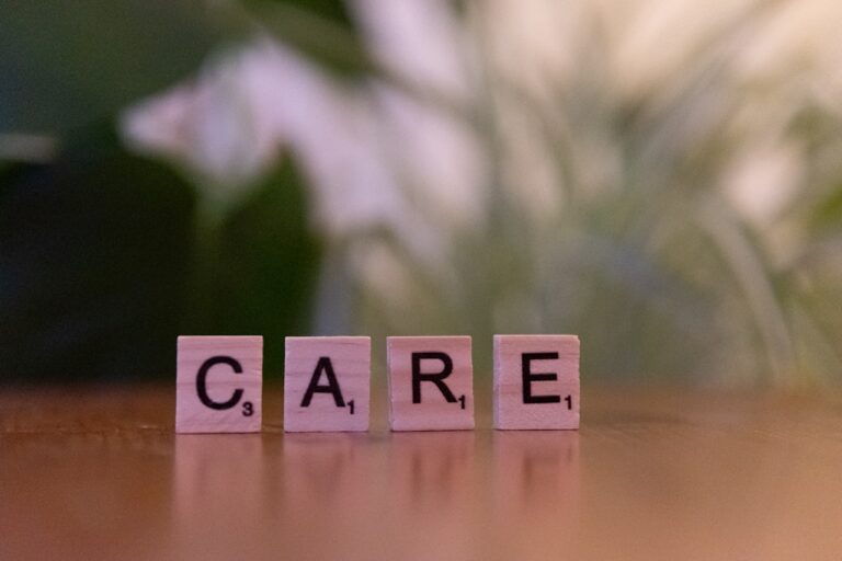 A wooden block spelling care on a table