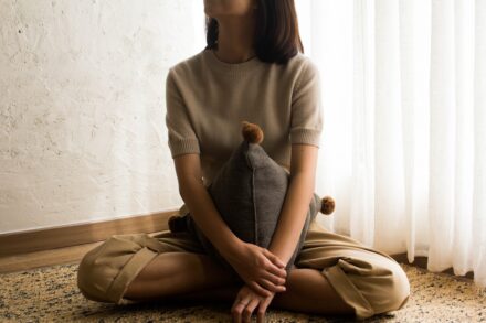 Emotional Healing woman in white knit sweater sitting on brown wooden seat