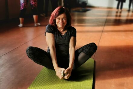 woman in black tank top and black pants lying on green mat