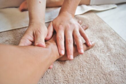 Healing Touch Massage Therapy 3 persons hand on persons lap