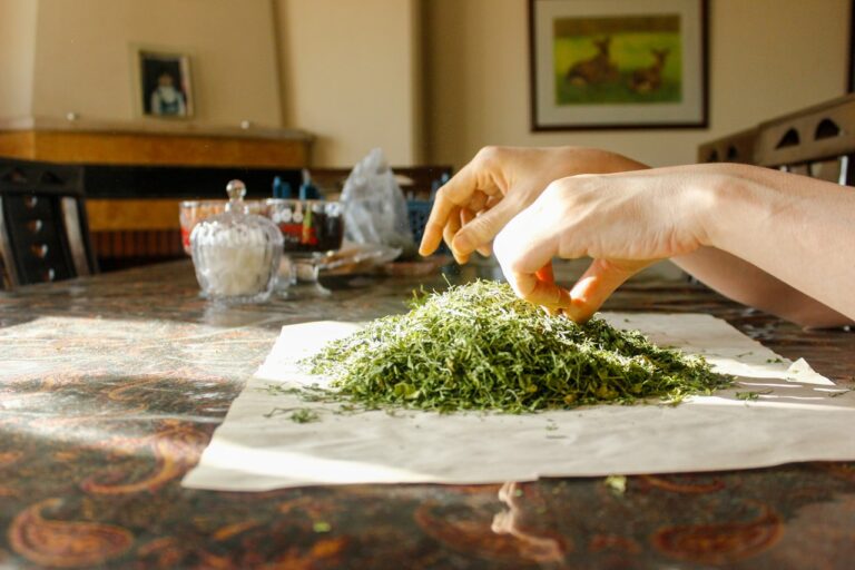 Herbal Medicine Hands sprinkle chopped greens onto a surface.