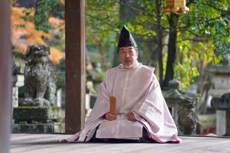 A priest sitting on the ground in a temple