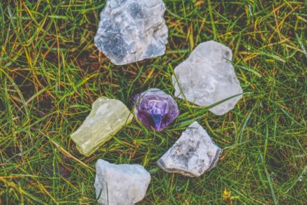 Crystal Healing a group of rocks sitting on top of a lush green field
