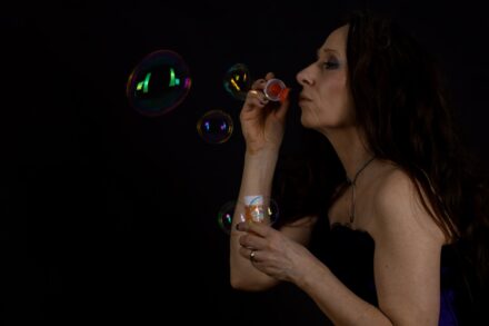 Crystal Healing a woman blowing bubbles in the dark