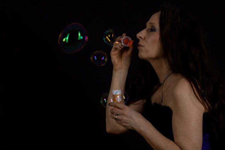 Crystal Healing a woman blowing bubbles in the dark