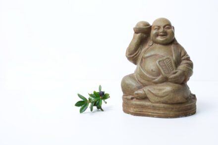 a small statue of a person holding a cell phone next to a small plant