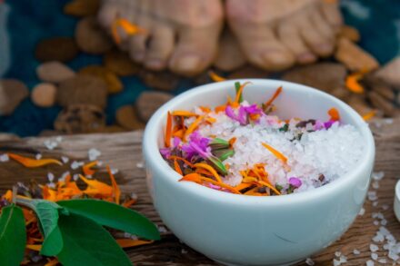 a bowl of sea salt with flowers in it