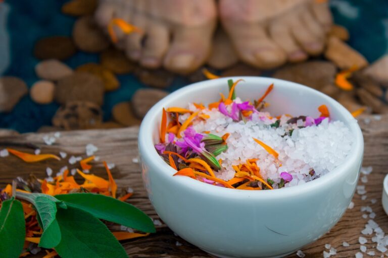 a bowl of sea salt with flowers in it