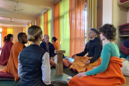People are meditating in a sunny and colorful room.