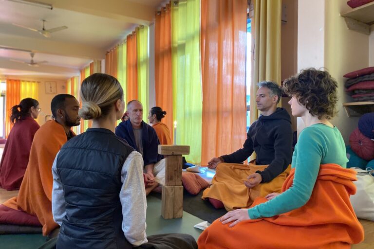 People are meditating in a sunny and colorful room.