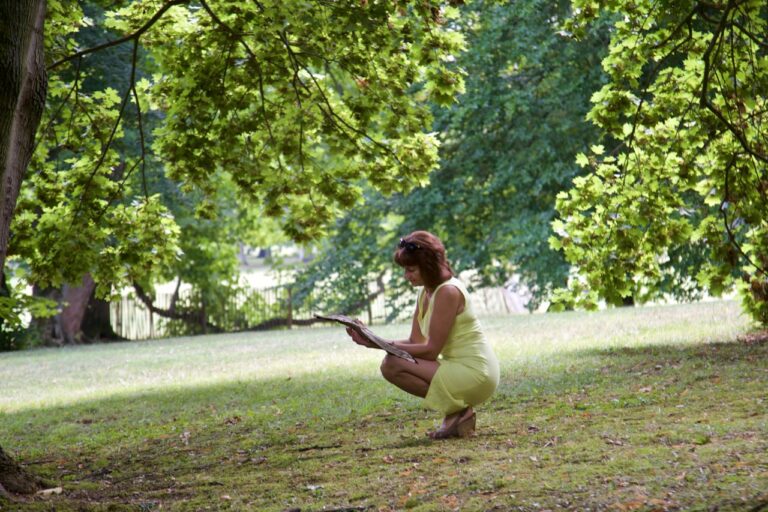 Holistic Healing a woman in a yellow dress crouches in the grass