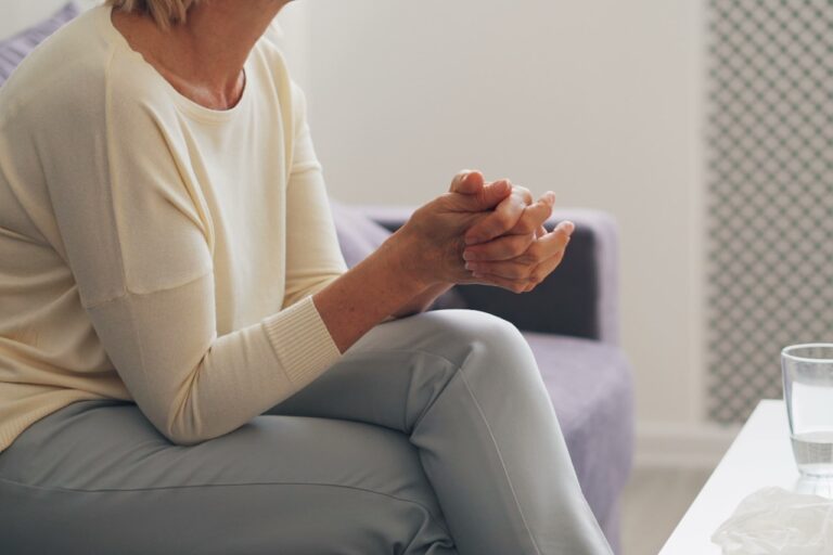 Holistic Healing a woman sitting on a couch holding her hands together