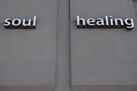 Holistic Healing a couple of signs that are on the side of a building