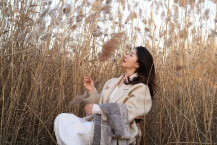 Holistic Healing a woman sitting in a field of tall grass