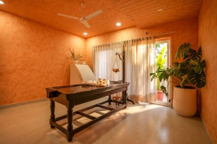 A massage table in a spa room with orange walls.