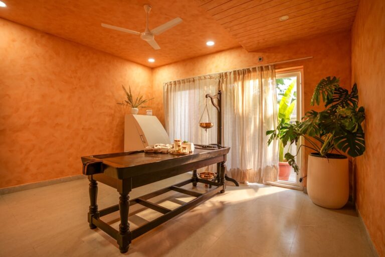 A massage table in a spa room with orange walls.