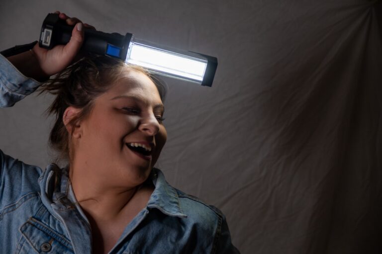 LED Nogier Frequency smiling woman in blue denim jacket holding microphone