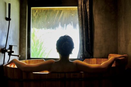 Listings a woman sitting in a bathtub in front of a window