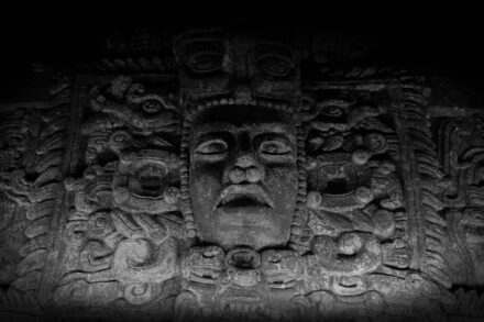 a black and white photo of a face on a wall