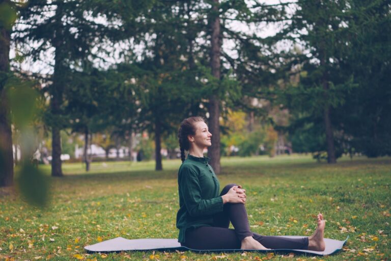 Woman practicing yoga on mat in park