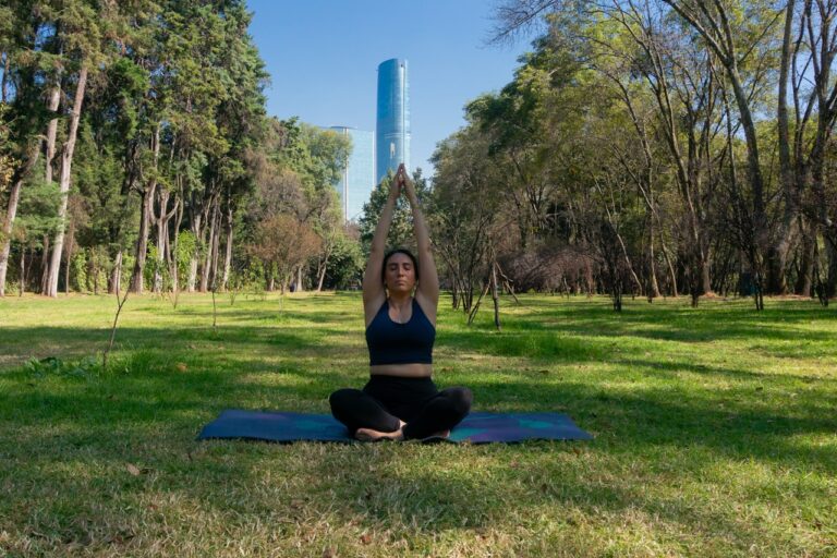 Mind-Body Healing Woman meditating on a yoga mat in a park.