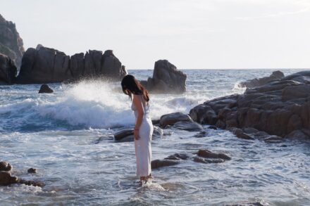 Mind-Body Healing Woman in white dress standing in shallow ocean water