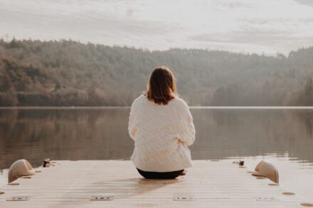 mind-gut connection diet healing chromatic woman in white long sleeve shirt sitting on brown wooden dock during daytime