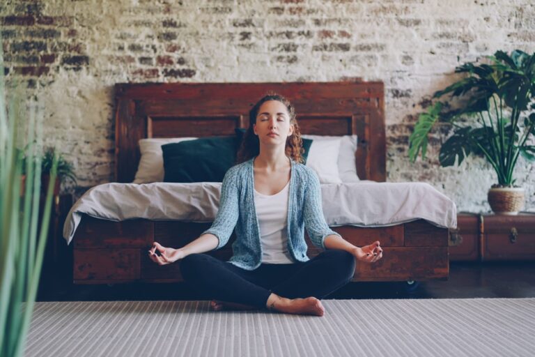 Mindful living rolfing plant-based Woman meditating cross-legged on the floor