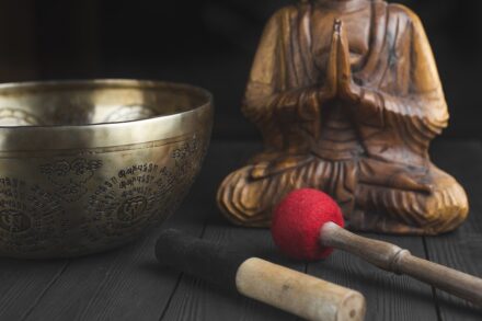 brass buddha figurine beside red and white stick