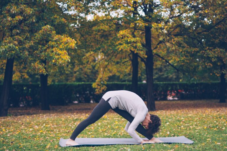 Quantum Healing & Techniques Woman doing yoga in a park during autumn.