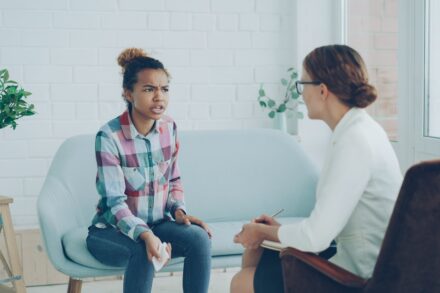 Quantum Healing & Techniques A woman talks to a therapist in an office.