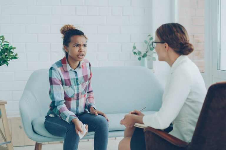 Quantum Healing & Techniques A woman talks to a therapist in an office.