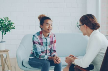 Quantum Healing & Techniques Two women talking in a modern office setting.