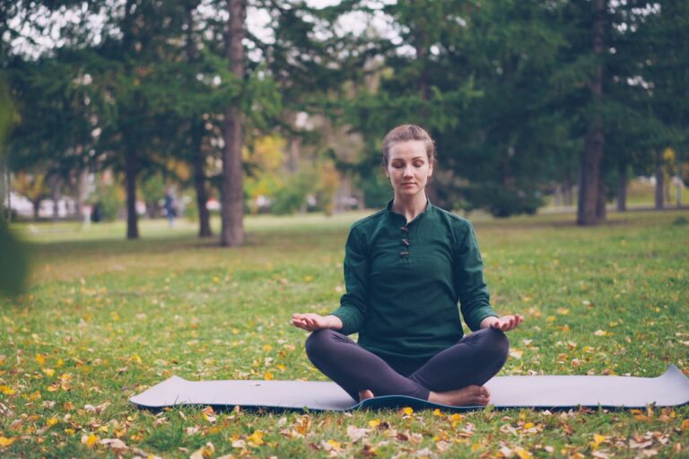 Quantum Healing & Techniques Woman meditating in a peaceful park setting