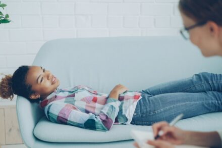 Quantum Healing & Techniques Girl lying on couch during therapy session with counselor