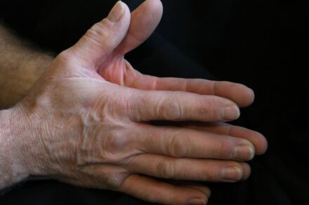 a person's hands with a black background