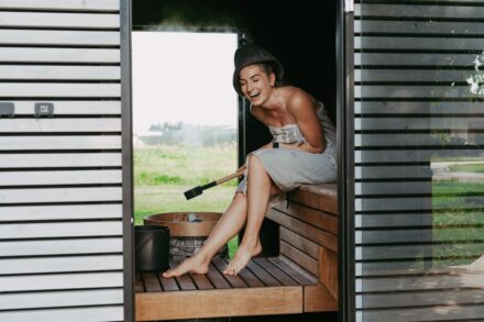 Quasar Quantum Healing Woman laughing in a steamy sauna with a whisk