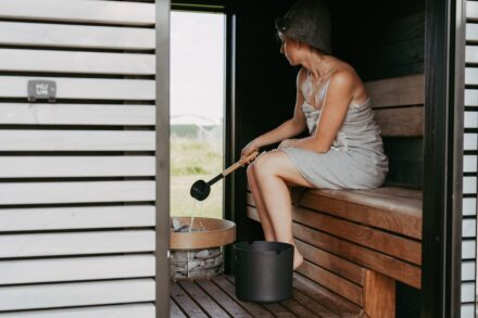 Quasar Quantum Healing Woman in sauna pours water on hot stones