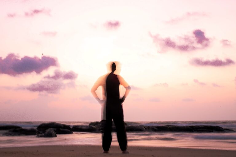 silhouette of woman standing on beach during sunset
