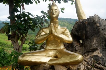 a statue of a person sitting on a rock