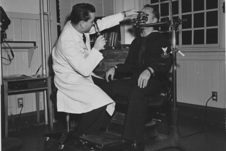 rTMS (Repetitive Transcranial Magnetic Stimulation) Doctor examines patient's eye with equipment.