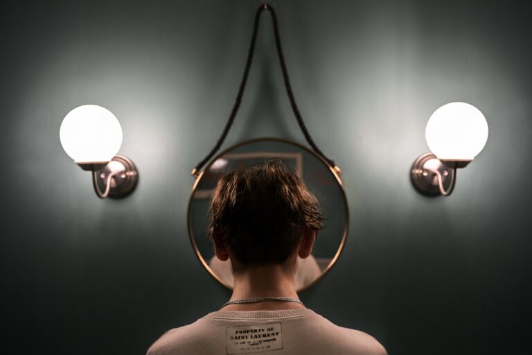 rTMS (Repetitive Transcranial Magnetic Stimulation) boy in white tank top standing in front of black and white wall lamp