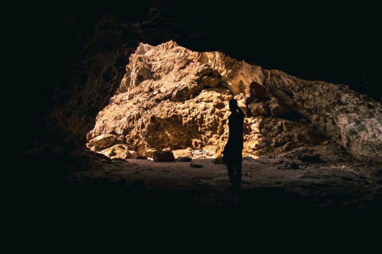 a person standing in front of a cave