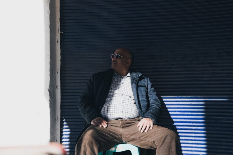 Salt Therapy man sitting on plastic chair while leaning on black wall