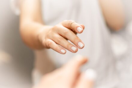 Aromatherapy person in white shirt holding babys hand