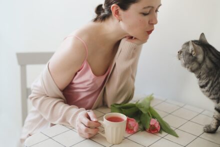 Aromatherapy a person sitting on a chair with a cat and a cup of tea