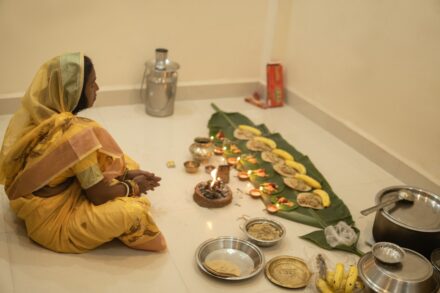 Spiritual and Cultural Healing Woman in yellow sari participates in a ritual with offerings.